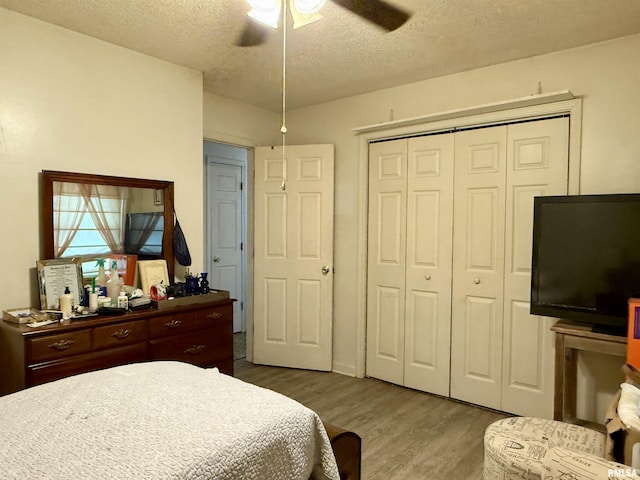 bedroom with a closet, ceiling fan, a textured ceiling, and wood finished floors