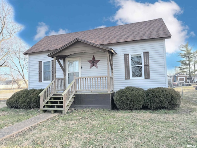 bungalow-style home featuring a shingled roof and a front lawn