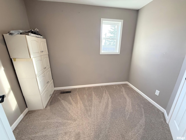 unfurnished room featuring baseboards, visible vents, and light colored carpet