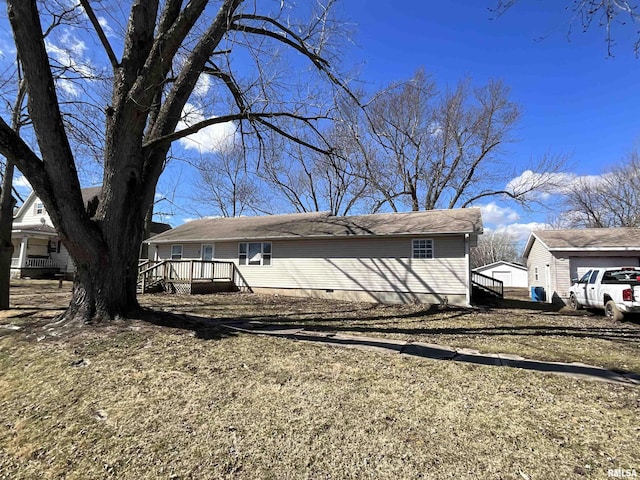 view of home's exterior with crawl space, a deck, and an outbuilding