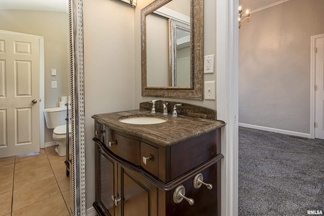 bathroom featuring tile patterned flooring, baseboards, vanity, and toilet