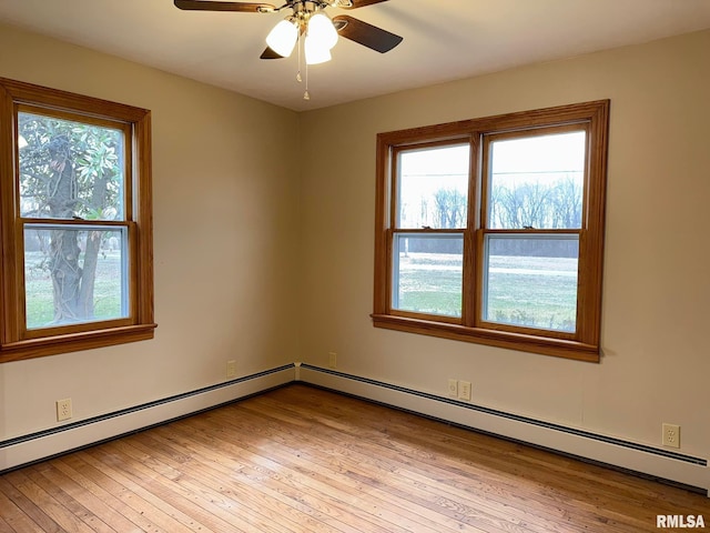 spare room with light wood-type flooring, ceiling fan, plenty of natural light, and baseboard heating