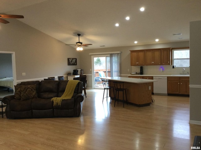 living room with lofted ceiling, light wood finished floors, a ceiling fan, and recessed lighting