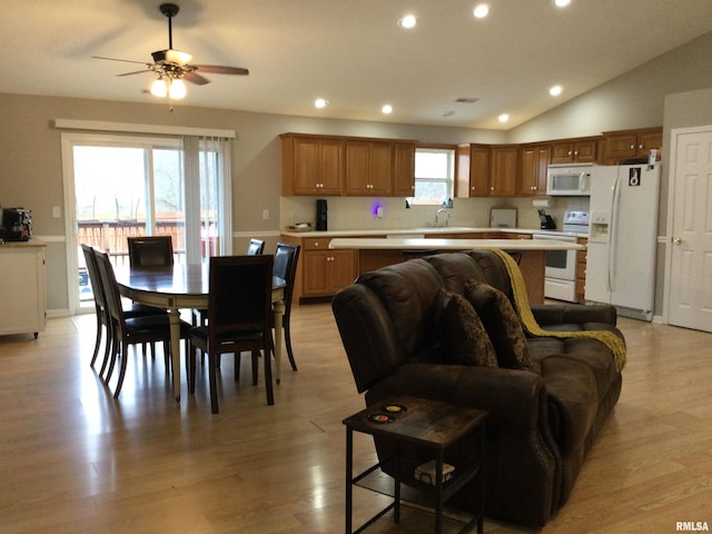 living area featuring light wood finished floors, vaulted ceiling, a ceiling fan, and recessed lighting