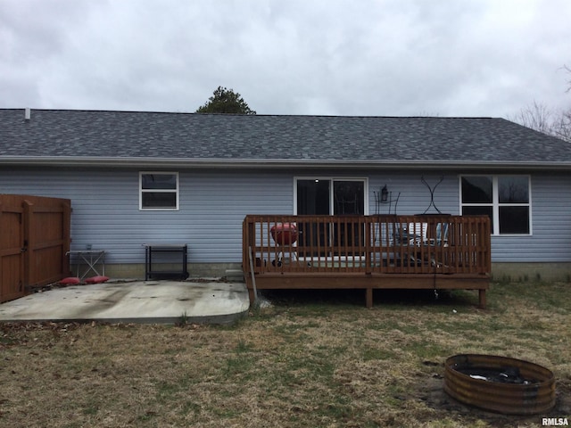 back of house with roof with shingles, a yard, a patio, fence, and a deck