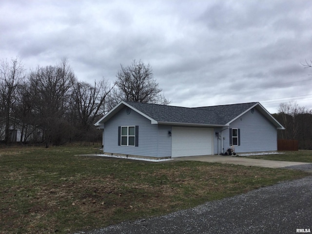 view of side of property featuring an attached garage, driveway, roof with shingles, and a yard