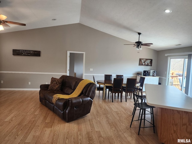 living room with light wood-style floors, lofted ceiling, and ceiling fan