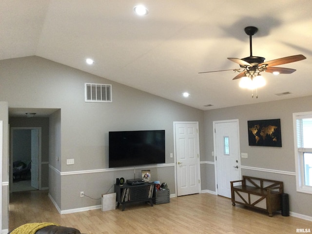 living room with lofted ceiling, visible vents, and wood finished floors