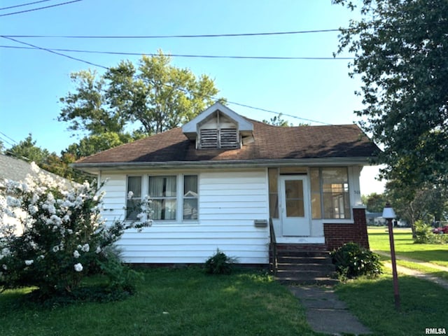 bungalow-style house with a front yard and entry steps