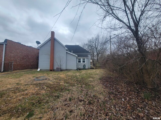 905 W Monroe St, Herrin, IL 62948 - view of property exterior featuring central air condition unit, a lawn, and fence