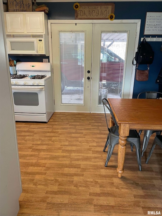 kitchen featuring french doors, white appliances, white cabinets, and light wood-style floors