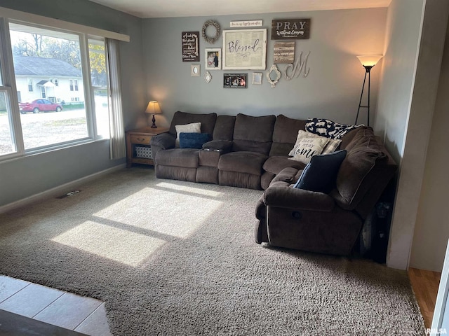 living room with carpet floors, visible vents, and baseboards