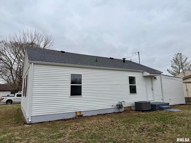 back of house featuring a yard, roof with shingles, and central air condition unit