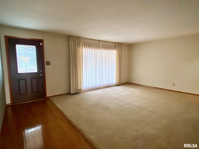 carpeted entryway featuring plenty of natural light and baseboards