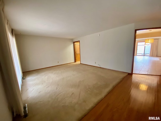 unfurnished room with light wood-type flooring and baseboards