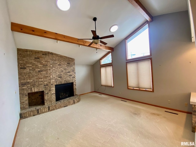 unfurnished living room with carpet floors, beam ceiling, a brick fireplace, ceiling fan, and baseboards