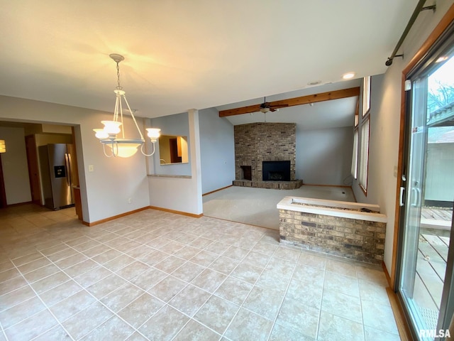 unfurnished living room with ceiling fan with notable chandelier, a fireplace, light tile patterned flooring, and baseboards