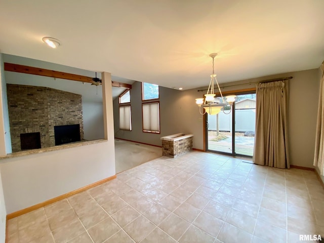 empty room with a large fireplace, baseboards, and light tile patterned floors