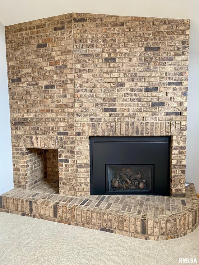 details with carpet and a brick fireplace