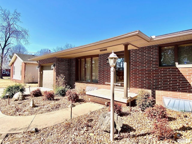 view of front of home with a garage, covered porch, and brick siding