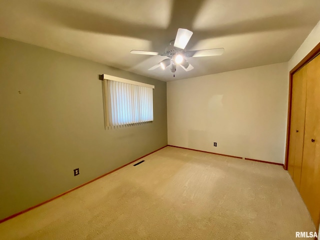 unfurnished bedroom with light carpet, baseboards, visible vents, and a ceiling fan