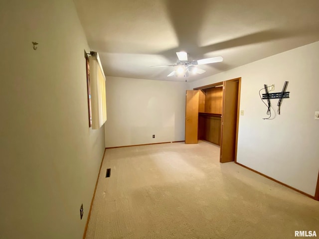 empty room with visible vents, baseboards, a ceiling fan, and light colored carpet