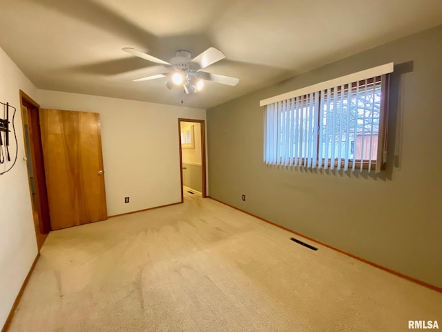 unfurnished bedroom featuring carpet floors, baseboards, visible vents, and a ceiling fan