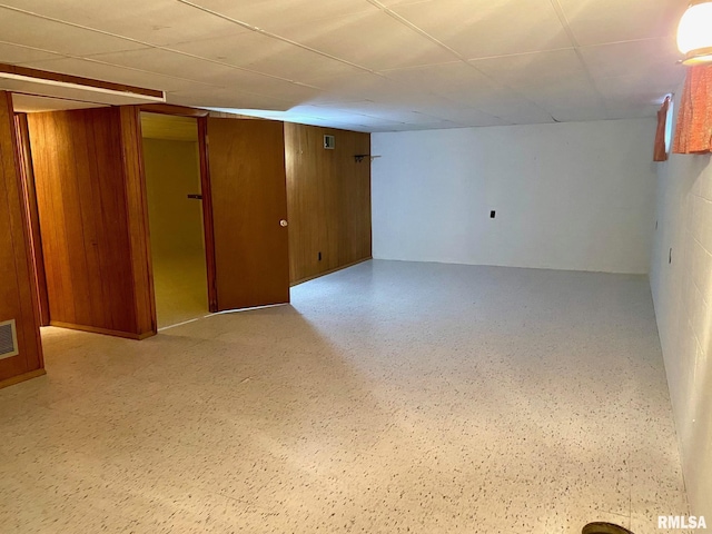 finished basement with visible vents and wooden walls