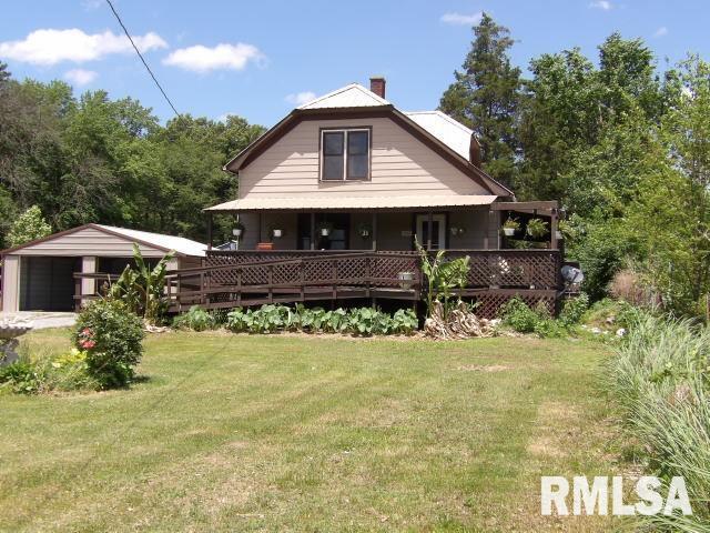 back of house with a yard, a chimney, and a detached garage