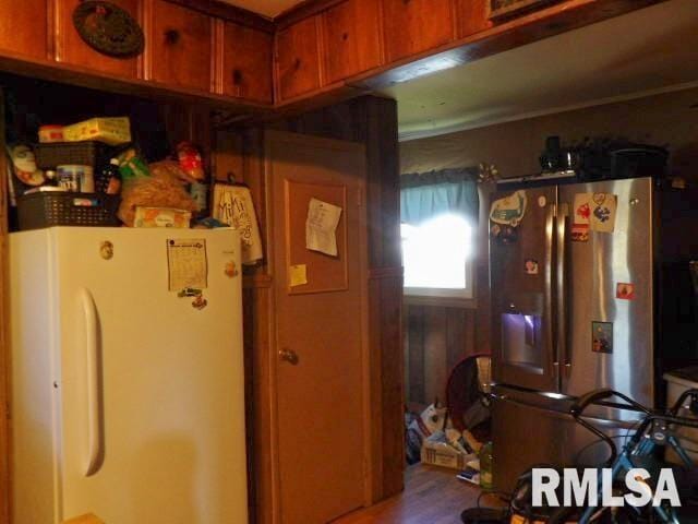 kitchen with stainless steel fridge, brown cabinetry, and freestanding refrigerator