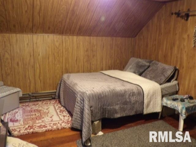 bedroom featuring lofted ceiling, wood walls, and wooden ceiling