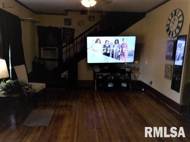 living room featuring baseboards, stairway, ceiling fan, and wood finished floors