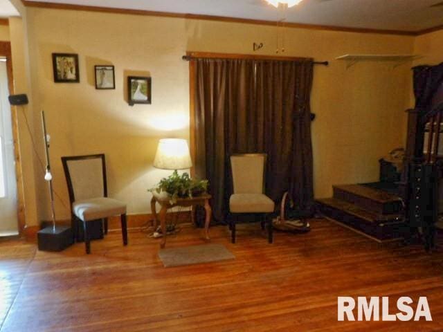 living area featuring wood finished floors and crown molding