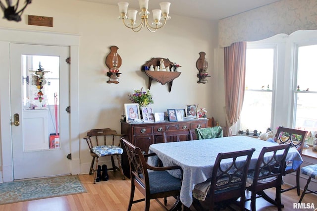 dining area with a chandelier, light wood-type flooring, and washer / dryer