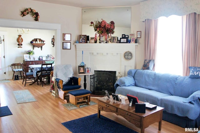 living area with light wood-style floors and a brick fireplace