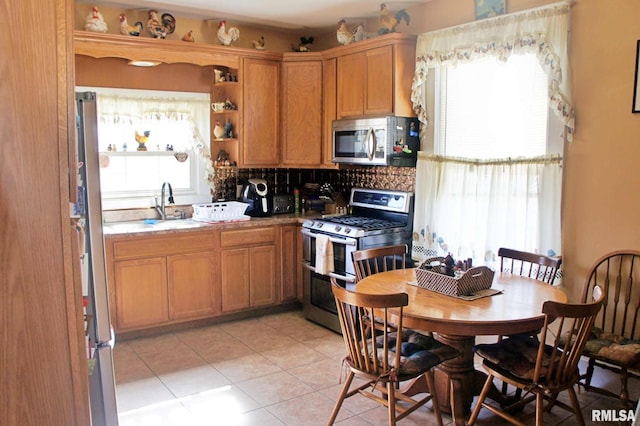 kitchen featuring light tile patterned floors, stainless steel appliances, open shelves, backsplash, and a sink