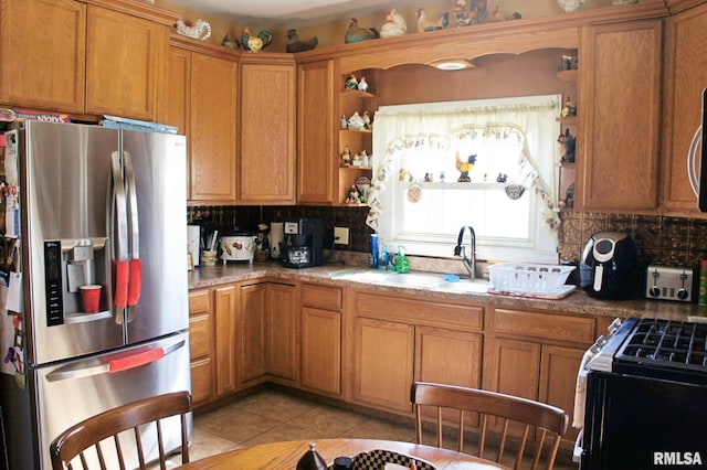 kitchen with tasteful backsplash, stainless steel fridge, a sink, and open shelves