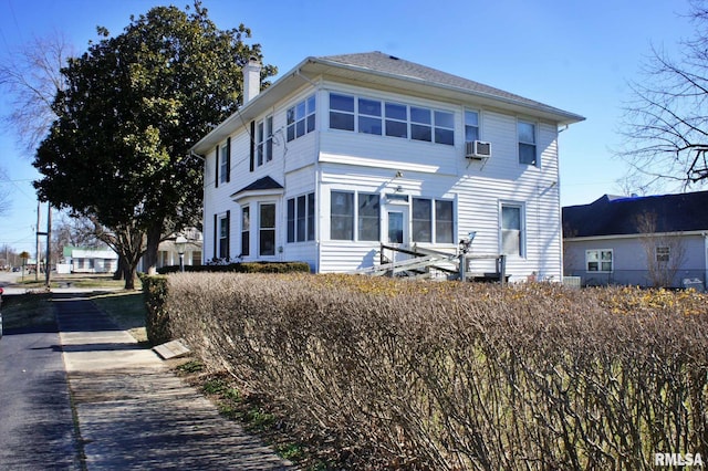 view of front of property with a sunroom and a chimney