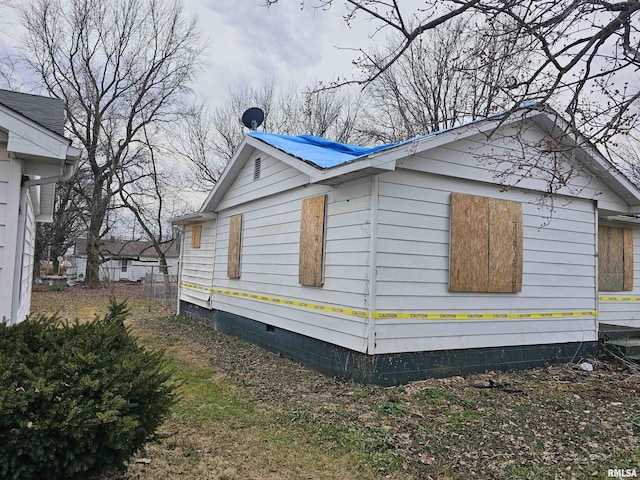 view of property exterior featuring metal roof and crawl space