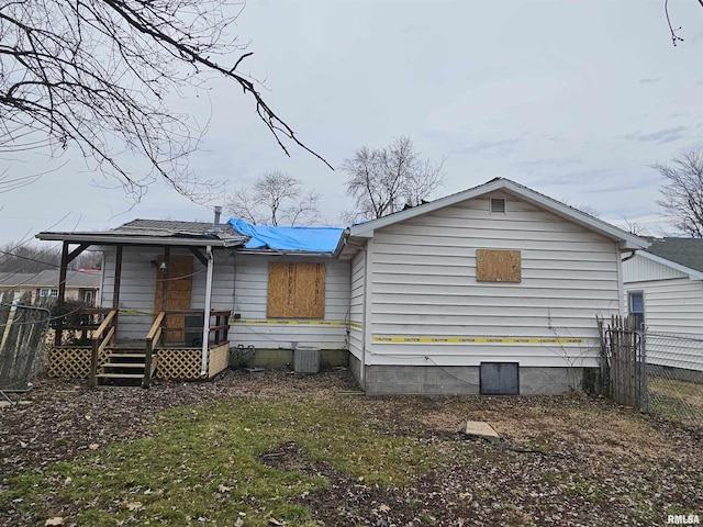 rear view of property with fence, a deck, and cooling unit