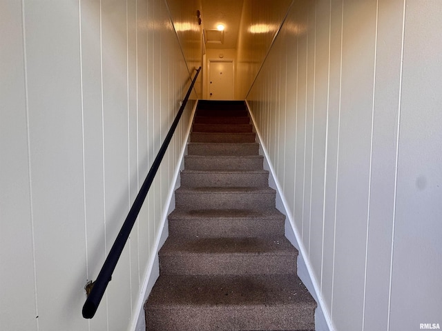 stairway featuring a decorative wall