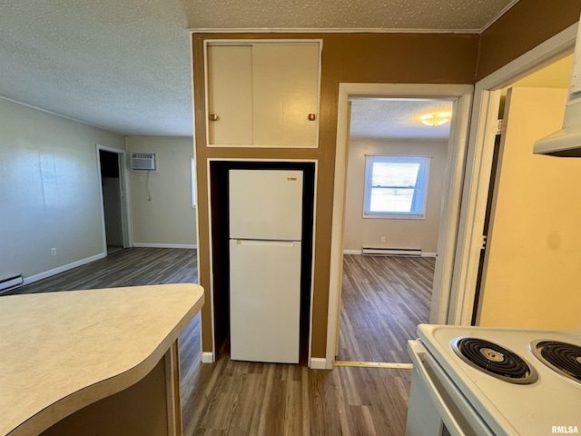 kitchen with dark wood-style flooring, baseboard heating, a textured ceiling, white appliances, and baseboards