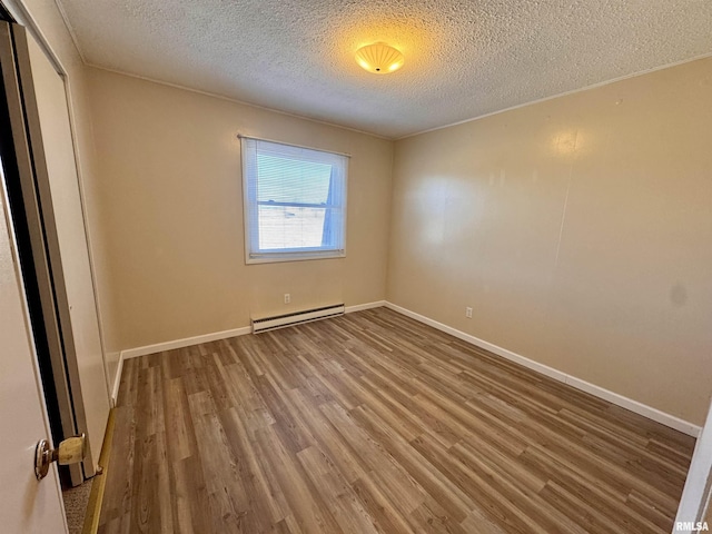 unfurnished room with a textured ceiling, a baseboard radiator, wood finished floors, and baseboards