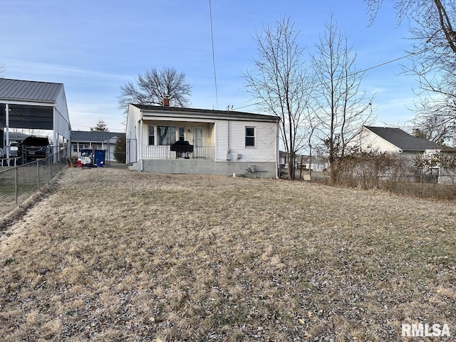 rear view of house with a chimney and fence