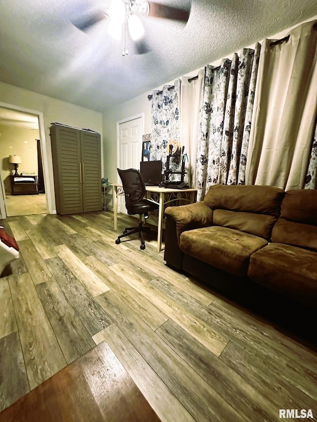 home office featuring ceiling fan, a textured ceiling, and hardwood / wood-style flooring