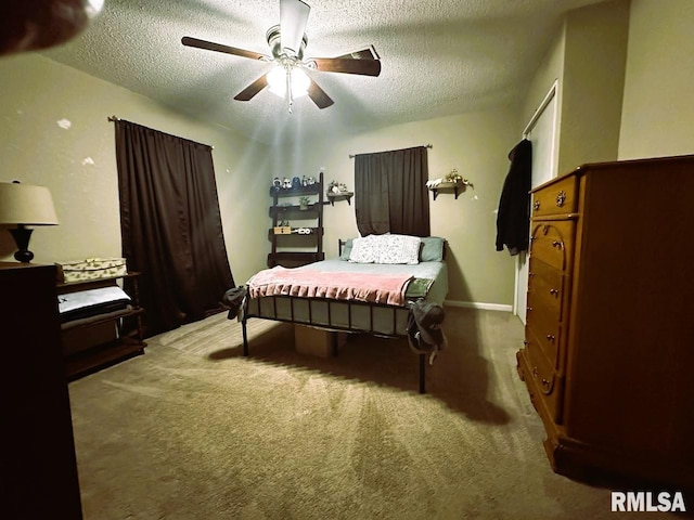 carpeted bedroom featuring a textured ceiling and ceiling fan