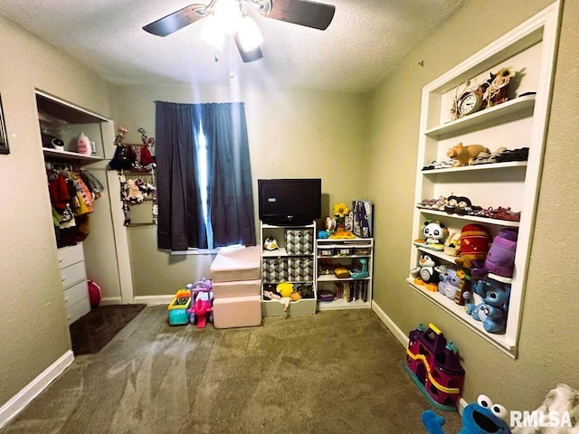 game room featuring baseboards, carpet, built in features, and a textured ceiling