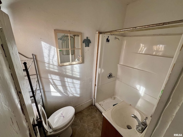 full bathroom with a sink, walk in shower, and toilet