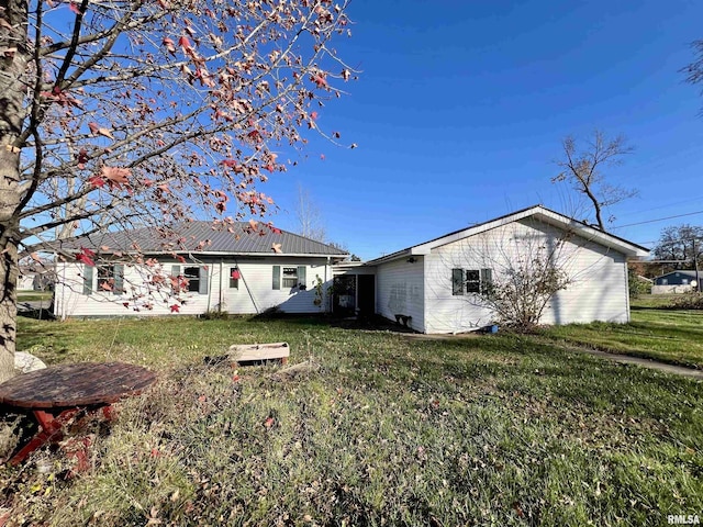 back of house with a lawn