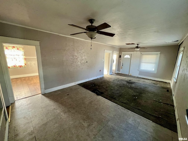 interior space with a ceiling fan, crown molding, and baseboards